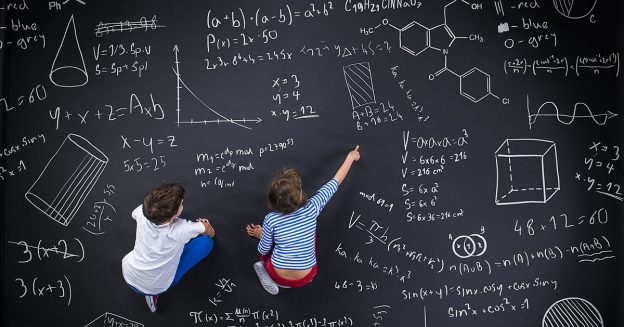 35548261 - cute boy and girl learning playfully in frot of a big blackboard